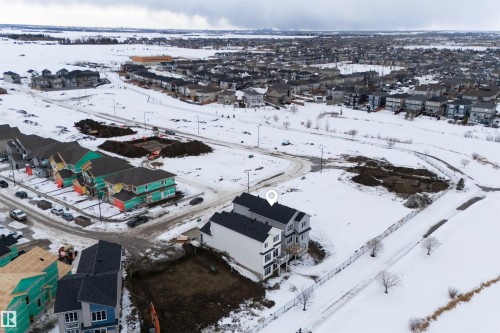 Aerial view showcasing the property within a developing neighborhood, featuring other residential properties and open, snow-covered spaces - 190 Elliott Wynd, Fort Saskatchewan, AB - Outdoor With View