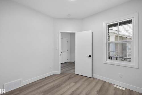 This room features light-colored walls and wood-look flooring - 190 Elliott Wynd, Fort Saskatchewan, AB - Indoor Photo Showing Other Room