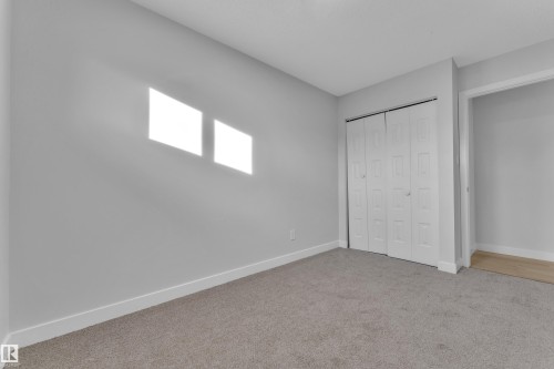 This room features light gray walls, white trim, and gray carpeted flooring - 5118 17A Ave, Edmonton, AB - Indoor Photo Showing Other Room