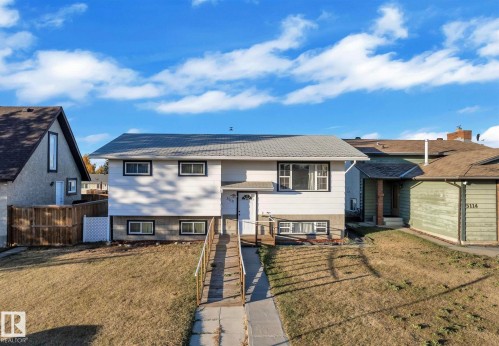 The property features a split-level design with a light-colored exterior and contrasting dark trim around the windows - 5118 17A Ave, Edmonton, AB - Outdoor