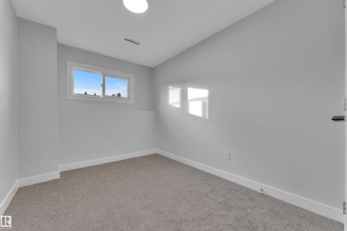 This room features a window providing natural light, light gray walls, and carpeted flooring - 5118 17A Ave, Edmonton, AB - Indoor Photo Showing Other Room