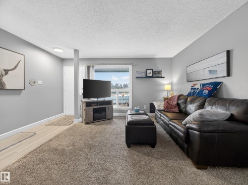 Living area featuring neutral-toned carpet, light gray walls, and a window providing an exterior view - 165 2703 79 Street, Edmonton, AB - Indoor Photo Showing Living Room