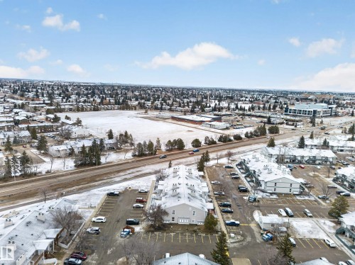Aerial view showcasing the expansive community, including residential buildings, parking areas, and a road - 165 2703 79 Street, Edmonton, AB - Outdoor With View