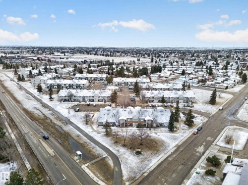 Aerial view of the property and its surrounding area, featuring paved roads, scattered trees, and buildings with snow-covered roofs - 165 2703 79 Street, Edmonton, AB - Outdoor With View