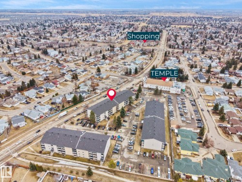This property is situated within a developed neighborhood, featuring residential buildings and a street with vehicle traffic - 214 2620 Mill Woods Road E, Edmonton, AB - Outdoor With View