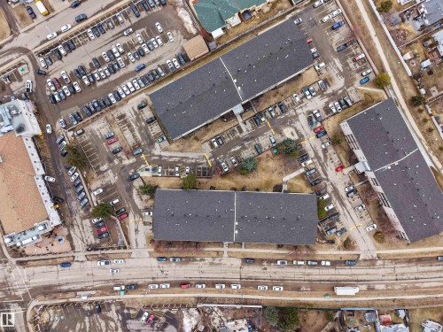 This property features several buildings with dark roofs and surrounding parking areas - 214 2620 Mill Woods Road E, Edmonton, AB - 