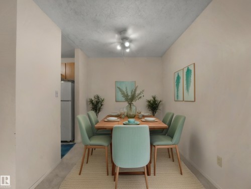 Dining area with a light wood table, upholstered chairs, and overhead lighting - 214 2620 Mill Woods Road E, Edmonton, AB - Indoor Photo Showing Dining Room