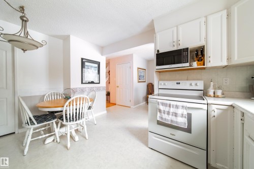 The kitchen features white cabinetry, a white stove, and a built-in microwave - 11 Granada Place, St. Albert, AB - Indoor Photo Showing Kitchen