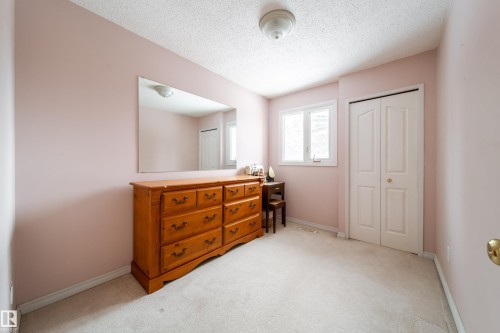 This room features light pink walls, light-colored carpeting, and a white bi-fold closet door - 11 Granada Place, St. Albert, AB - Indoor