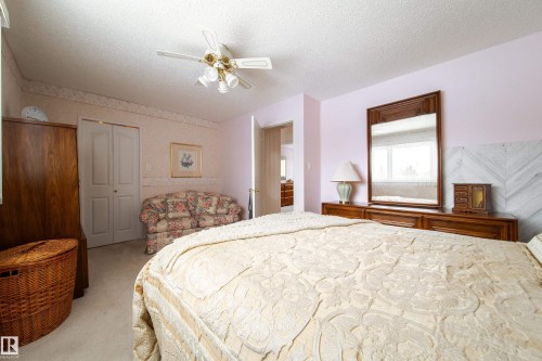 This bedroom features carpeting, a ceiling fan, and a light-colored wall with a patterned border - 11 Granada Place, St. Albert, AB - Indoor Photo Showing Bedroom