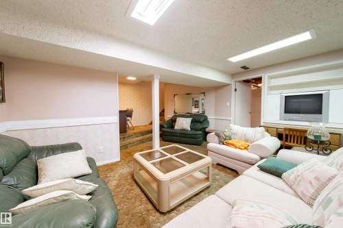 Spacious room featuring light colored walls, a dropped ceiling, and a built-in entertainment center - 11 Granada Place, St. Albert, AB - Indoor