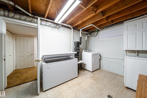 Utility area featuring exposed wooden beams, fluorescent lighting, tiled flooring, and white walls - 11 Granada Place, St. Albert, AB - Indoor Photo Showing Laundry Room
