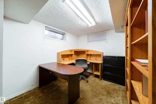 The property features a dedicated workspace with a built-in wooden desk, shelving, and a window - 11 Granada Place, St. Albert, AB - Indoor Photo Showing Office