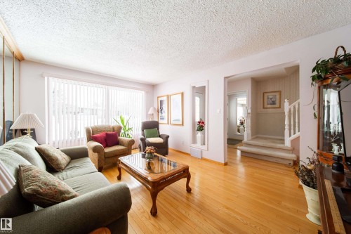 The living area features hardwood floors and a large window with vertical blinds, providing ample light - 11 Granada Place, St. Albert, AB - Indoor Photo Showing Living Room