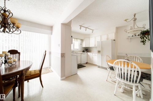 Bright dining area and kitchen featuring white cabinetry and appliances - 11 Granada Place, St. Albert, AB - Indoor Photo Showing Dining Room