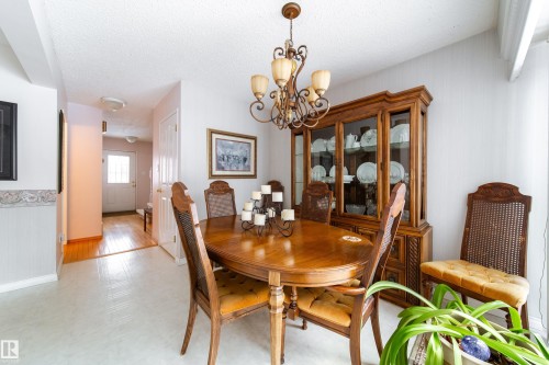 The dining area features a chandelier, light-toned walls, and a visible doorway with a white door - 11 Granada Place, St. Albert, AB - Indoor Photo Showing Dining Room
