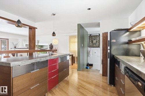 The kitchen features hardwood floors, a stone countertop, and pendant lighting - 11026 110 Avenue, Edmonton, AB - Indoor Photo Showing Kitchen