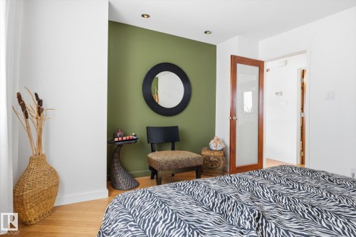 This room features hardwood floors and a wall accent in a vibrant green hue - 11026 110 Avenue, Edmonton, AB - Indoor Photo Showing Bedroom