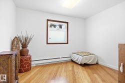 This room features light hardwood flooring and a window with a dark wood trim - 