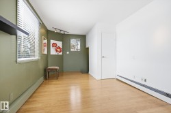 This room features light hardwood flooring, painted walls, and window blinds - 
