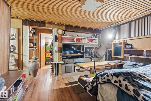Interior room featuring wood plank flooring, a slatted wood ceiling, and a prominent wood paneled wall - 11026 110 Avenue, Edmonton, AB - Indoor