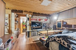 Interior room featuring wood plank flooring, a slatted wood ceiling, and a prominent wood paneled wall - 