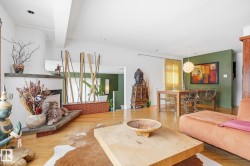 This spacious living area features hardwood floors and a fireplace with a stone mantel - 