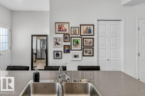 Kitchen featuring a double stainless steel sink with a chrome faucet set into a speckled grey countertop - 3708 42 Avenue, Beaumont, AB - Indoor Photo Showing Kitchen With Double Sink