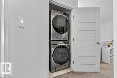 Dedicated laundry area featuring a stacked washer and dryer unit - 3708 42 Avenue, Beaumont, AB - Indoor Photo Showing Laundry Room