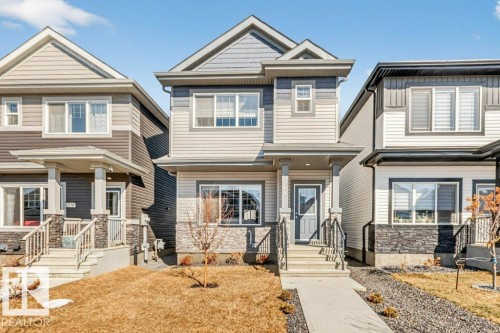 The property features a two-story exterior with light-colored siding and dark trim accents - 3708 42 Avenue, Beaumont, AB - Outdoor With Facade