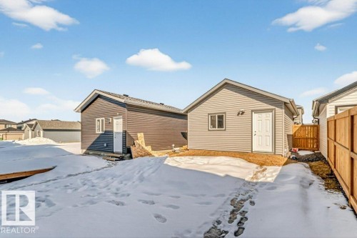 The property features two detached structures with siding exteriors and pitched roofs, offering versatile utility - 3708 42 Avenue, Beaumont, AB - Outdoor