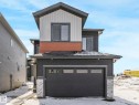 The property features a two-story exterior with dark gray siding and white vertical siding accents - 239 Kinglet Boulevard Nw, Edmonton, AB  - Outdoor 