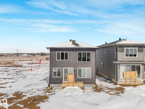 The property features gray siding, a dark roof, and multiple windows across two visible levels - 239 Kinglet Boulevard Nw, Edmonton, AB - Outdoor