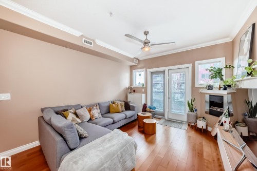 Living area featuring hardwood flooring, crown molding, and a modern ceiling fan - 307 10121 80 Avenue, Edmonton, AB - Indoor Photo Showing Living Room