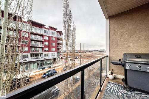 The property features a balcony with a glass railing and a textured exterior wall - 307 10121 80 Avenue, Edmonton, AB - Outdoor With Balcony