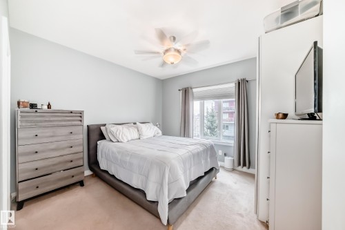 Bedroom featuring light-colored walls, carpeted flooring, and a ceiling fan - 307 10121 80 Avenue, Edmonton, AB - Indoor Photo Showing Bedroom
