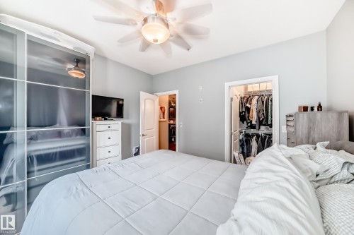This bedroom features a ceiling fan with integrated lighting, light blue walls, and a closet with an open doorway - 307 10121 80 Avenue, Edmonton, AB - Indoor Photo Showing Bedroom