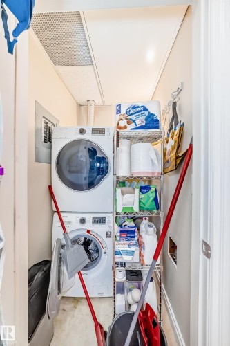 Dedicated laundry area featuring stacked appliances and durable flooring - 307 10121 80 Avenue, Edmonton, AB - Indoor Photo Showing Laundry Room