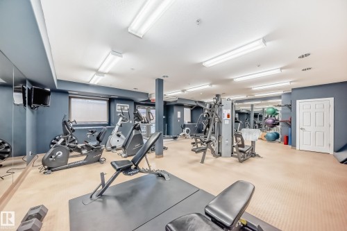 Fitness center featuring exercise equipment, ample lighting, and mirrored walls - 307 10121 80 Avenue, Edmonton, AB - Indoor Photo Showing Gym Room