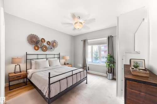 This bedroom features light-toned walls, a ceiling fan, and a window with curtains - 307 10121 80 Avenue, Edmonton, AB - Indoor Photo Showing Bedroom