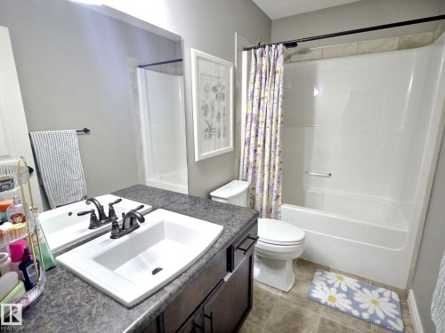 Bathroom featuring a vanity with a white sink and dark bronze faucet, a matching dark bronze towel bar, and a toilet - 5718 Rue Eaglemont, Beaumont, AB - Indoor Photo Showing Bathroom