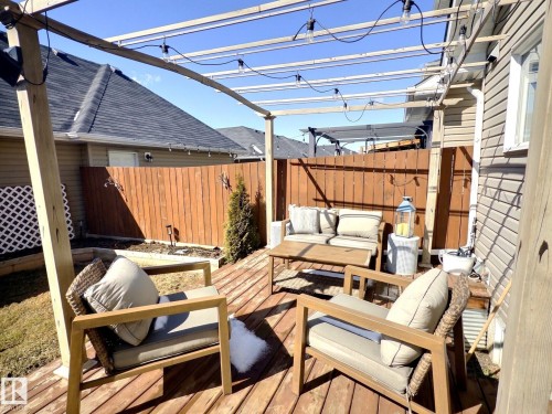 The property features a wood deck with a pergola structure above, equipped with string lighting - 5718 Rue Eaglemont, Beaumont, AB - Outdoor With Deck Patio Veranda