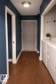 Entryway featuring wood flooring, a ceiling-mounted light fixture, and a laundry area with appliances - 4 3819 76 Street, Edmonton, AB  - Indoor 