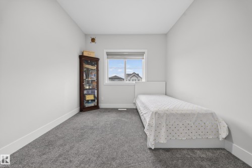 The room features soft grey carpeting, light-colored walls, and a window providing natural light - 449 Roberts Crescent, Leduc, AB - Indoor Photo Showing Bedroom