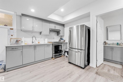 Well-appointed kitchen featuring light-toned cabinetry, stainless steel appliances, and light-colored flooring - 449 Roberts Crescent, Leduc, AB - Indoor Photo Showing Kitchen