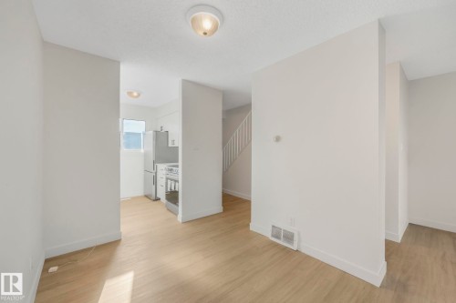 Spare room featuring light wood finished floors and a textured ceiling - 5833 Riverbend Road, Edmonton, AB - Indoor Photo Showing Other Room