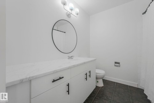 Bathroom featuring vanity, dark tile patterned flooring, and a shower with shower curtain - 5833 Riverbend Road, Edmonton, AB - Indoor Photo Showing Bathroom