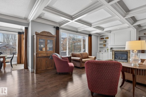 Living space featuring hardwood flooring, a coffered ceiling, and a fireplace with a mantel - 20719 51 Avenue, Edmonton, AB - Indoor Photo Showing Other Room With Fireplace