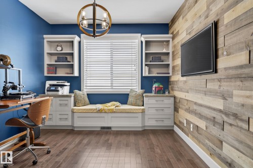 This versatile space features hardwood flooring, a unique wood-paneled accent wall, and a window with blinds - 20719 51 Avenue, Edmonton, AB - Indoor Photo Showing Office
