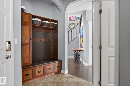 Welcoming entryway featuring a built-in wooden hall tree with storage, a bench, and coat hooks - 20719 51 Avenue, Edmonton, AB - Indoor Photo Showing Other Room